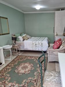 伯诺尼Victorian Villa Westdene Benoni的一间卧室配有一张床、一张桌子和一张地毯。