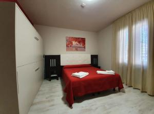 比亚恩卡维拉Hotel Casale dei Greci的一间卧室配有红色的床和红色毯子
