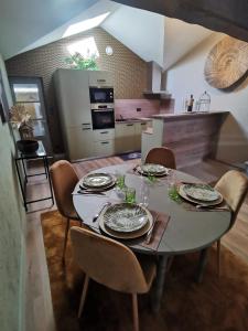 绍莱La Canopée的厨房配有带盘子和玻璃杯的桌子