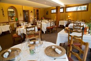 埃斯坦奥博格圣特福鲁特酒店的用餐室配有白色桌椅和玻璃杯