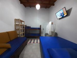 卡拉瓜塔图巴A VER O MAR FLATS的客厅配有蓝色的沙发和双层床。