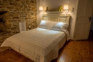 拉夫科斯Ξενώνας Λαύκος的卧室配有白色的砖墙床