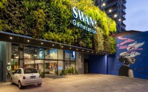 阿雷格里港Swan Generation Porto Alegre的停在植物建筑前面的汽车