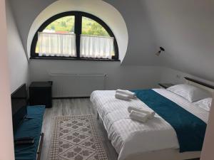 普特纳Casa Românească的一间卧室设有两张床和大窗户