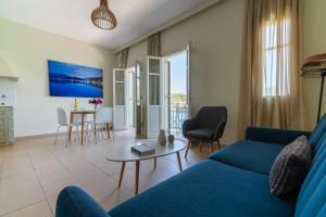 瓦西Hotel Omirikon的客厅配有蓝色的沙发和桌子