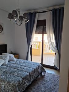 克萨达城AGRADABLE ADOSADO CON PISCINA的一间卧室设有一张床和一个大窗户