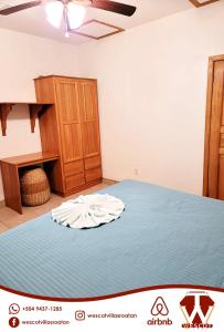 罗阿坦Sunset Waves的一间卧室配有一张床和一个木制橱柜