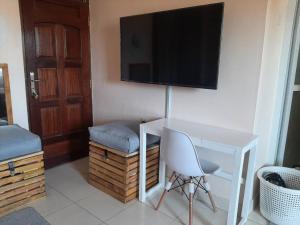 Mto PangaMacy's Studio Apartment的一间房间,配有一张桌子和一台墙上的电视