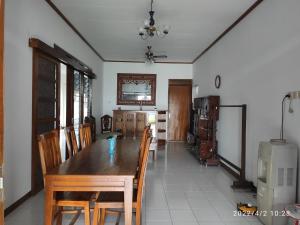 三宝垄Kelana 2 Nice Homestay (5 Bed Rooms) Semarang的一间带木桌和椅子的用餐室