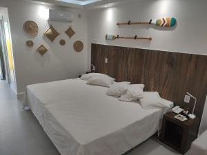 布希奥斯Búzios Beach Resort Residencial 1305的卧室配有一张白色大床和木制床头板