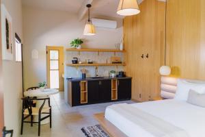 棕榈泉Azure Sky Hotel - Adults Only的一间卧室配有一张床铺和一张桌子,还设有一间厨房