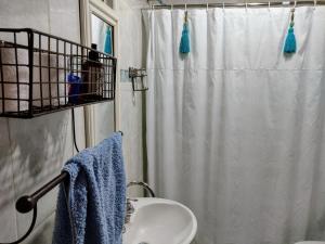梅赛德斯M&A Alquileres的浴室设有白色的淋浴帘和水槽