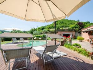 乌尔比诺Belvilla by OYO Villa Angolo Fiorito的一个带遮阳伞和椅子的甲板和一个游泳池