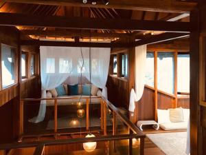 塞贝维Grand Serene Lakeside Bali Style Villa的船上的一张床位,带窗户