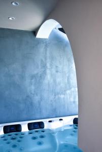 费拉Villa Galaxy Santorini的浴室配有蓝色的墙壁和浴缸。