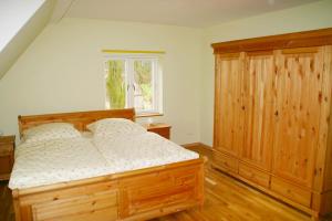 HollenbekHof Viehbrook的一间卧室配有木床和木柜