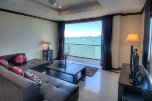 苏梅岛Emerald Beach-Front Apartments Fishermans Village的带沙发和大窗户的客厅