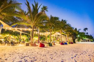 美奈晃玉海滩度假酒店的棕榈树沙滩和餐厅