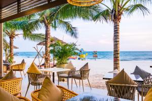 美奈晃玉海滩度假酒店的海滩上的餐厅,种有棕榈树,享有海景