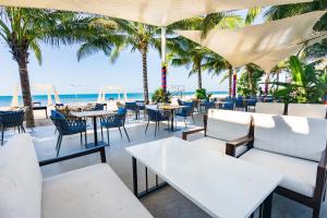 美奈晃玉海滩度假酒店的海滩上的餐厅,配有桌椅