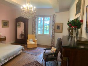 GoustranvilleLe Manoir des Bréholles的一间卧室配有一张床和一个吊灯