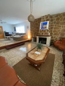 贝尼多姆Villa Mis 5 Amores con piscina的客厅设有石制壁炉和桌子。