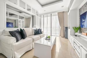 雅加达BLANC by Kozystay - 1BR Apartment in SCBD的白色的客厅配有白色的沙发和桌子