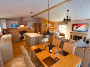佩恩顿Luxury Lodge - Hoburne Devon Bay的厨房以及带餐桌的起居室。