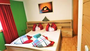 GaichtKlause-Stüberl的一间卧室配有红色和白色枕头的床