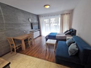 博格泽利卡Sea&Forest Pogorzelica Apartament Perłowy的一间卧室配有一张床、一张沙发和一张桌子