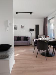 格但斯克Apartament 150 Zaspa VVita z ogrodem i tarasem的客厅配有桌子和沙发