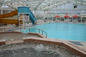 斯凯格内斯The Pearl - Deluxe Access Caravan的一个带水滑梯的大型室内游泳池