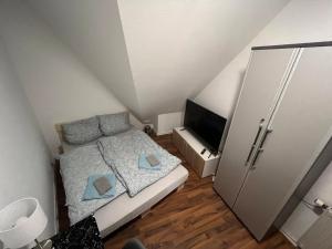 维尔茨堡Zimmer in Innenstadtwohnung的一间小卧室,配有一张床和电视