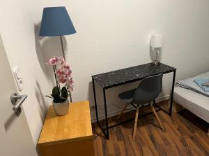维尔茨堡Zimmer in Innenstadtwohnung的客房配有带台灯和椅子的书桌