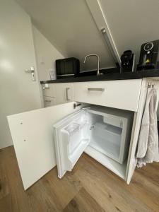 登堡Boetje 51的白色小厨房配有水槽和冰箱