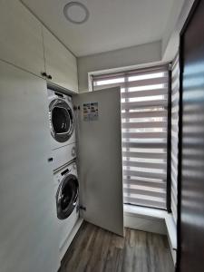 爱丁堡LOLO PROPERTIES 2, Free Parking的洗衣房设有洗衣机和烘干机,毗邻窗户