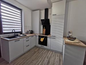 爱丁堡LOLO PROPERTIES 2, Free Parking的厨房配有白色橱柜、水槽和冰箱。