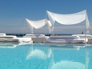丽都迪萨维奥维士塔梅赫套房酒店的一个带白色床和水的游泳池