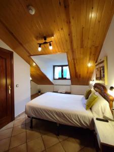 SiesteHotel Rural LAbadia de Sieste的一间卧室设有一张带木制天花板的大床