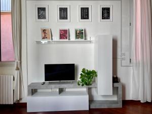 博洛尼亚LA CHIAVE DI VIOLINO Appartamentino musicale的一间客厅,在白色的墙上配有电视