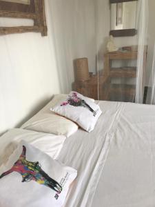 大博格LES ALOÈS By CREYOL ANIMAL的配有2张床的带白色床单和枕头的客房