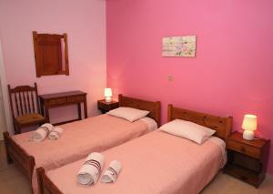 阿尔戈斯托利翁Kantouni House Kefalonia的配有粉红色墙壁的客房内的两张床