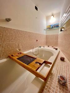 CollestatteMARMORE HOUSE的浴室设有浴缸,上面装有葡萄酒杯