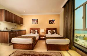 科威特布拉沃皇家套房酒店 的酒店客房设有两张床和窗户。