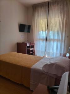 西尔米奥奈德比酒店的酒店客房设有两张床、一张桌子和一台电视。