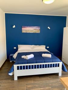 圣维托罗卡波Appartamento Il Pomodoro的蓝色的卧室,配有一张蓝色墙壁的床