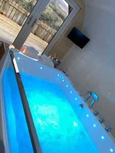 威廉堡Apex Studio Pod & Jacuzzi Bath的窗户客房内的大蓝色浴缸