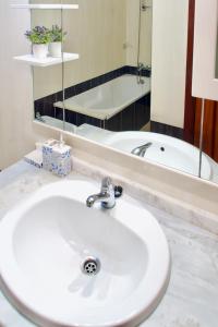费拉古多Edifício Tomás的浴室配有盥洗盆、镜子和浴缸
