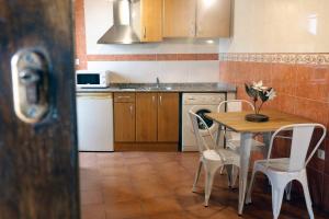 拉斯特雷斯LOFT NORDESTE的厨房配有木桌、椅子和桌子