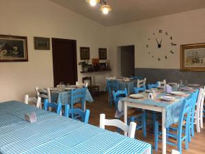 AustisAZIENDA AGRITURISTICA S'ARGALASI - B&B - AFFITTACAMERE Loc S'Argalasi Austis的餐厅设有蓝色的桌椅和时钟